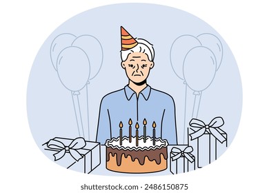 Sad old birthday person celebrating alone standing near table with gifts and cake and needing support of friends. Frustrated grandfather is sad because there are no guests for birthday parties