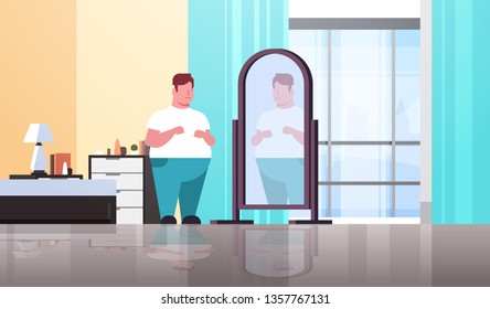 sad overweight man looking at himself reflection in mirror guy over size obesity concept modern apartment bedroom interior flat full length horizontal