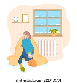 A sad woman with a cat under a blanket in a cold house