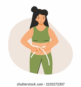A sad woman measures her stomach with a centimeter tape. The problem with being overweight. Fatness.