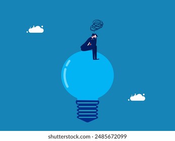 Sadness and lack of light in life. Businessman sitting stressed on a burned out light bulb 