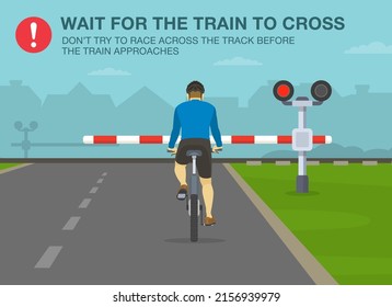 Safe bicycle riding rules and tips. Wait for the train to cross, don't try to race across the track before the train approaches. Back view of a cyclist at railroad crossing.