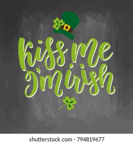 Saint Patricks Day greeting card with sparkled green clover leaves and text. Inscription - Kiss Me, I am Irish. St. Patricks Day lettering. Vector holiday poster sign on chalkboard background