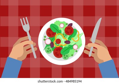 Salad and hands holding knife and fork