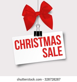 Sale Design for Christmas - Paper with Text "Christmas Sale" Hanging on Twine with Red Gift Ribbon