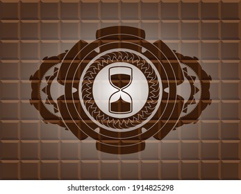 sand clock icon inside chocolate bar badge. Brown luxurious background. Illustration. 