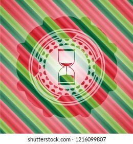 sand clock icon inside christmas colors emblem.