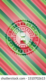 sand clock icon inside christmas badge.