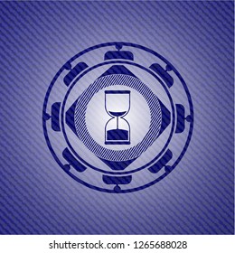 sand clock icon inside emblem with denim texture