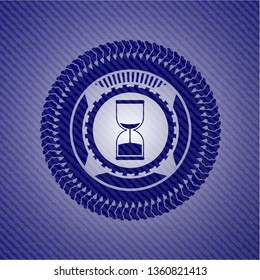 sand clock icon inside emblem with jean background