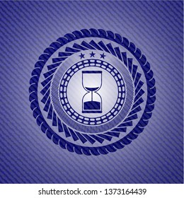 sand clock icon inside emblem with denim high quality background