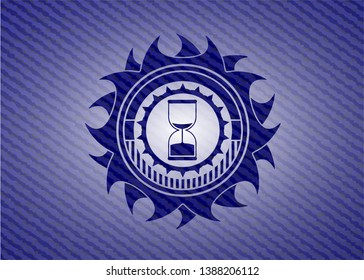 sand clock icon inside emblem with jean background