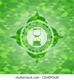 sand clock icon inside green emblem with mosaic ecological style background