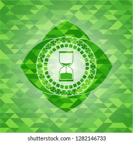 sand clock icon inside green emblem with mosaic background