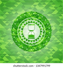 sand clock icon inside green emblem. Mosaic background