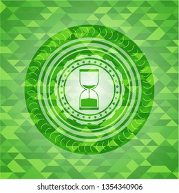 sand clock icon inside green emblem. Mosaic background