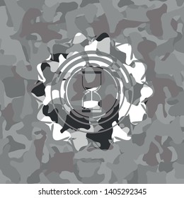 sand clock icon inside grey camouflage emblem