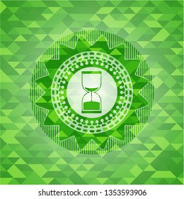 sand clock icon inside realistic green mosaic emblem