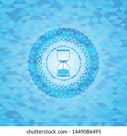 sand clock icon inside realistic light blue mosaic emblem