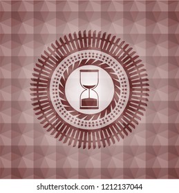 sand clock icon inside red seamless emblem with geometric pattern.