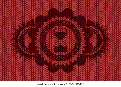 sand clock icon inside Red wool emblem. Cloth exquisite background. Illustration. 