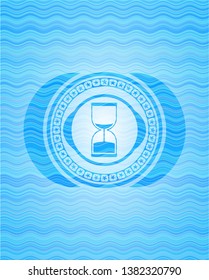 sand clock icon inside water wave emblem.