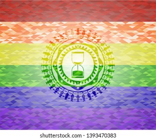 sand clock icon on mosaic background with the colors of the LGBT flag