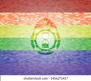 sand clock icon on mosaic background with the colors of the LGBT flag