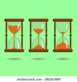 Sandglass with orange sand on green background