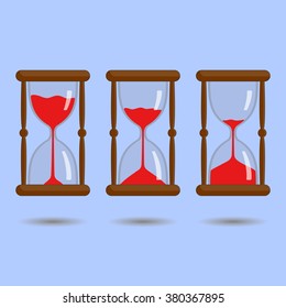 Sandglass with red sand on blue background