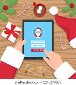 Santa Claus is log in to his digital account - flat design vector illustration. Santa is holding his tablet on wooden desk.