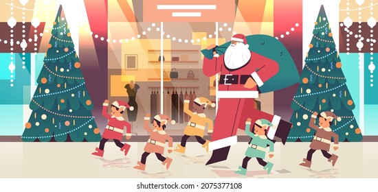 santa claus with mix race elves preparing for new year and christmas holidays celebration modern shopping mall