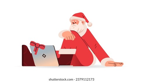 santa claus in red costume sitting on floor and using laptop happy new year merry christmas holidays celebration concept