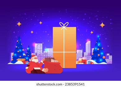 santa claus in red costume sitting near world map and gift boxes using laptop happy new year merry christmas holidays celebration concept
