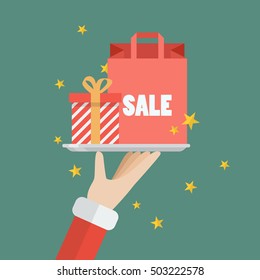 Santa Claus serving a present and shopping bag