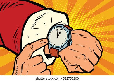 Santa Claus shows the clock, nearly midnight. Pop art retro vector illustration. New year and Christmas. Wrist watch with dial