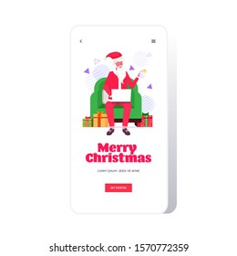 santa claus sitting in armchair using laptop and drinking tea merry christmas happy new year winter holidays celebration concept smartphone screen online mobile app full length vector illustration
