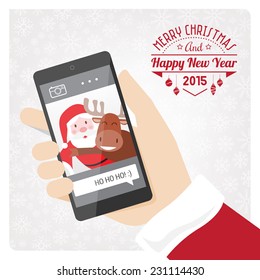 Santa claus taking a selfie with a reindeer using a smartphone.