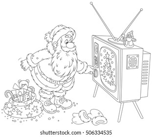 Santa Claus turning on his old wood TV set 