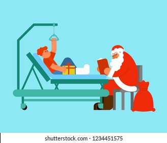 Santa Claus Visits in hospital. Grandfather reads book and gives gift. Boy with broken leg. Child on Hospital bed. Christmas in hospital. Medical care