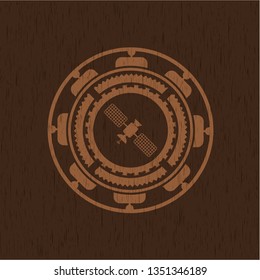 satelite icon inside badge with wood background