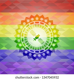 satelite icon inside emblem on mosaic background with the colors of the LGBT flag