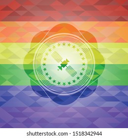 satelite icon inside emblem on mosaic background with the colors of the LGBT flag