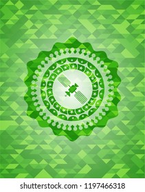 satelite icon inside green emblem with mosaic background
