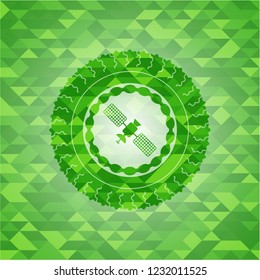 satelite icon inside green emblem with mosaic ecological style background