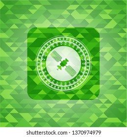satelite icon inside green emblem with triangle mosaic background