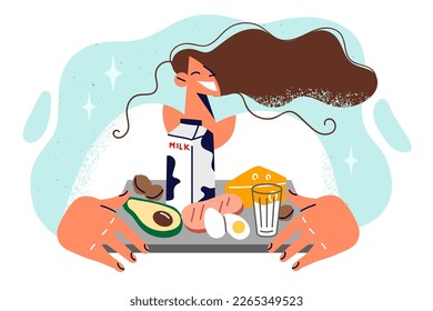 Satisfied woman with natural fresh food on tray preparing for hearty breakfast consisting of animal products and avocados. Girl eats high-calorie foods containing proteins and fats to increase weight