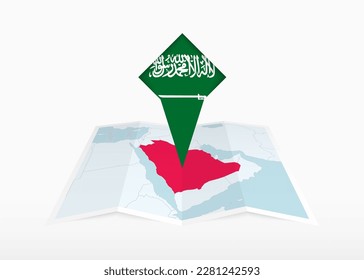 Saudi Arabia is depicted on a folded paper map and pinned location marker with flag of Saudi Arabia. Folded vector map.