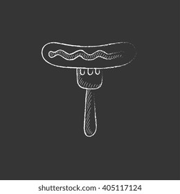 Salchicha sobre tenedor. Dibujado en un icono de tiza.