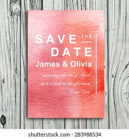 Save the date wedding invitation with watercolor pink backgound. Card template design on a wooden background.
